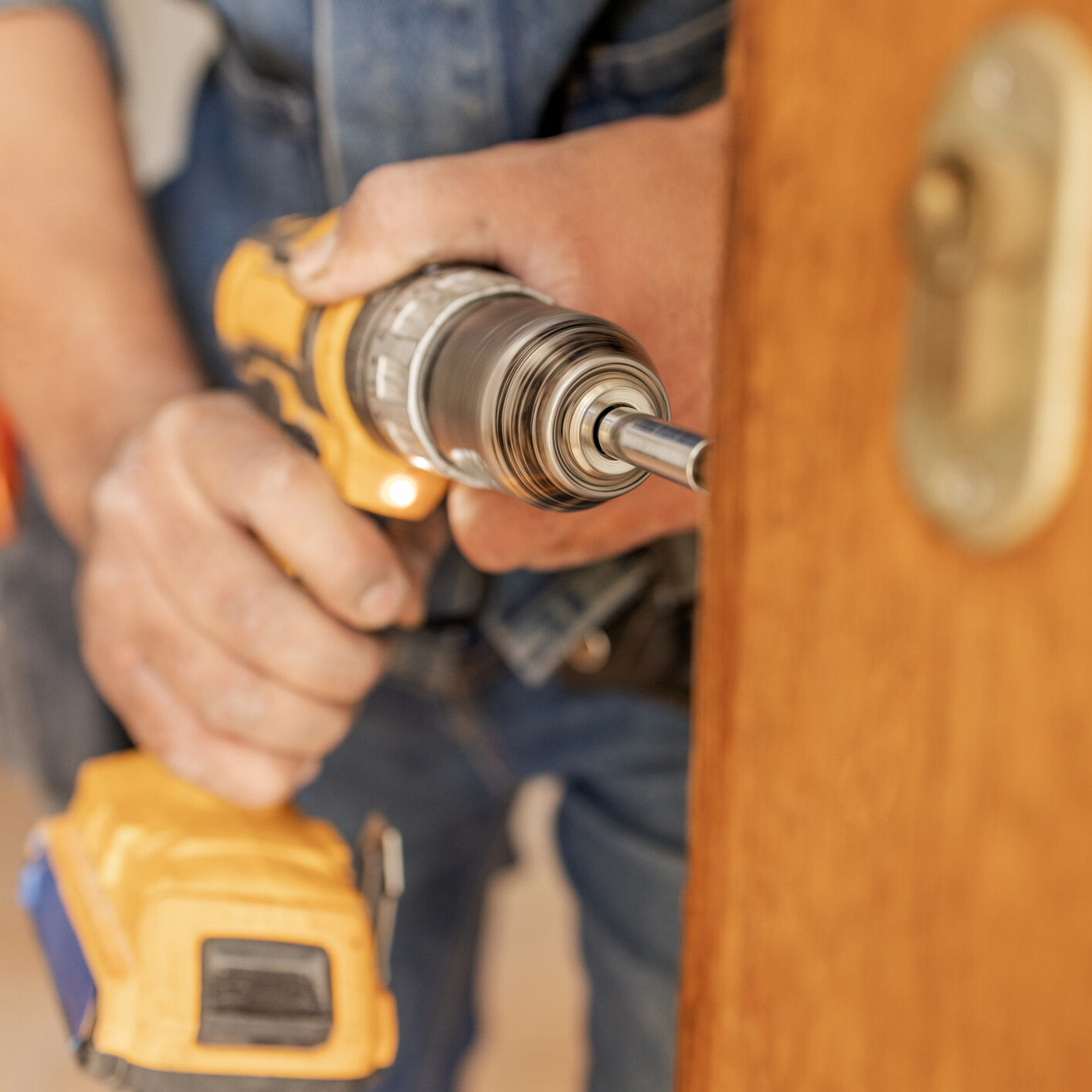 Locksmith, maintenance and handyman with drill, home renovation and fixing, change door locks with power tools. Construction, building industry and trade with manual labour, vocation and employee