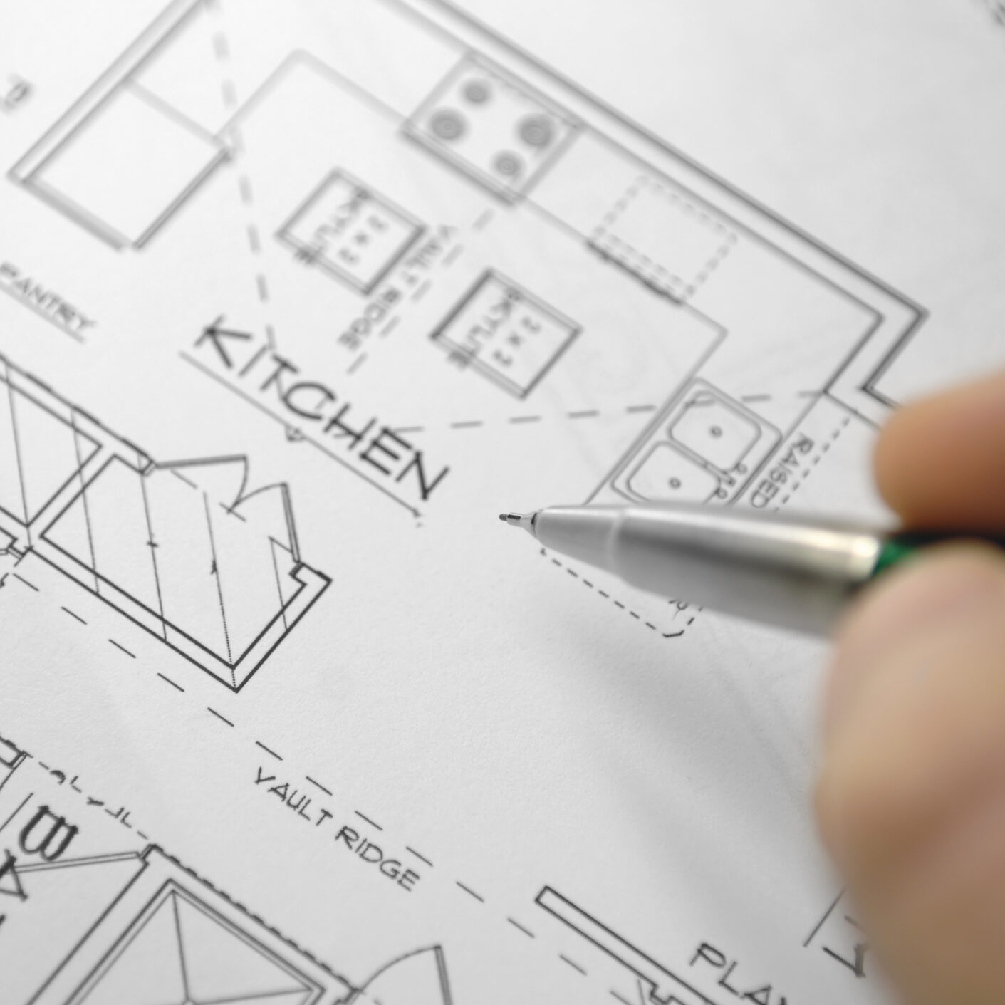 selective focus image of architectural drawings and hand holding mechanical pencil